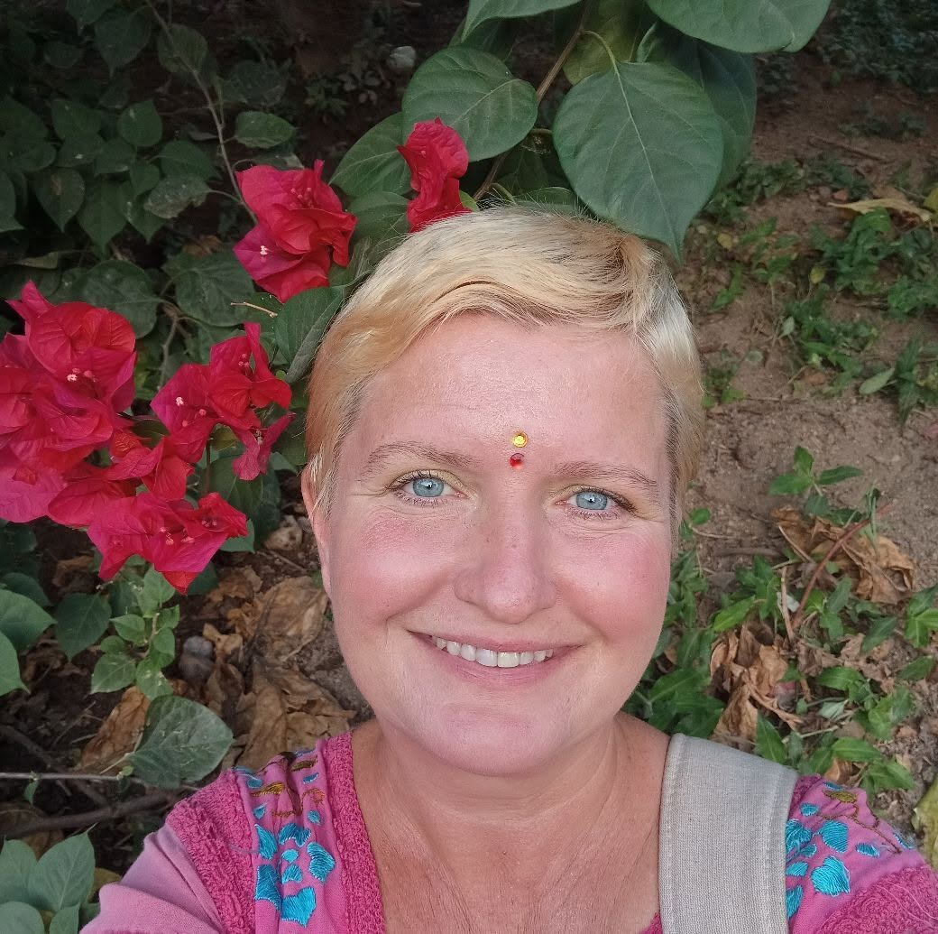 Natalia Volanberg smiling among bougainvillea flowers
